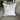 Plaid background with with white fuzzy bunny on front pillow cover on couch 