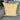 Back side of a yellow throw pillow featuring a solid woven texture, displayed on a gray couch.