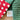 Close-up of red and white patterned fabric, green textured fabric, and a 'Wilshire Collections' label on a wooden surface.