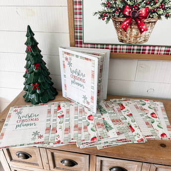 Christmas-themed stationery set on a wooden surface with decorative elements.